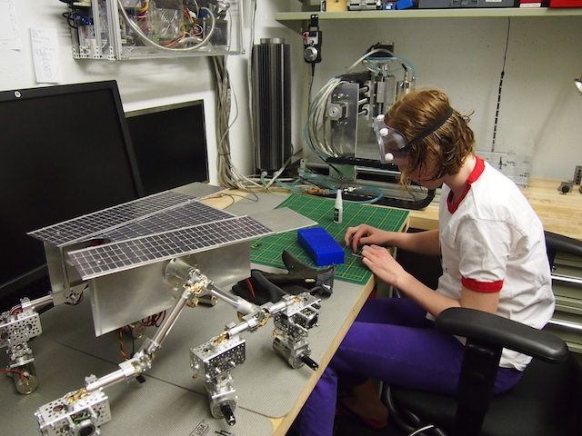 Camille works on assembling the thin film solar panels that will cover the top deck of the Mars Rover.